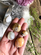 Load image into Gallery viewer, I gate tumbled stones sit in hand above for and antique wood
